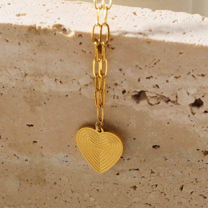 Style ALARA: Mini Paper Clip Chain Anchoring a Patterned Heart Charm in Gold